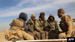 Syrian Democratic Forces (SDF) sit in the back of a truck near Raqqa earlier this week. 