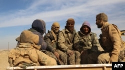 SDF forces sit in the back of a truck in the village of Abu al-Ilaj, some 50 kilometers north of Raqqa, on November 7.