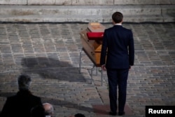French President Emmanuel Macron pays his respects at the coffin of slain teacher Samuel Paty in Paris on October 21.