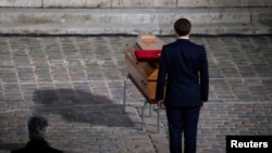 French President Emmanuel Macron pays his respects at the coffin of slain teacher Samuel Paty at a memorial event in Paris on October 21.