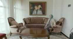 Айза Ахмадова в своем доме. На стене – портреты ее супруга и дочери Аминат