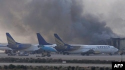 Smoke rises after militants launched an early morning assault at Jinnah International Airport in Karachi on June 9.