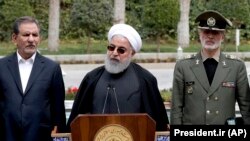 Iranian President Hassan Rohani, center, speaks during a media briefing after a cabinet meeting, as senior Vice President Eshaq Jahangiri, left, and Defense Minister Gen. Amir Hatami listen, in Tehran, March 18, 2019