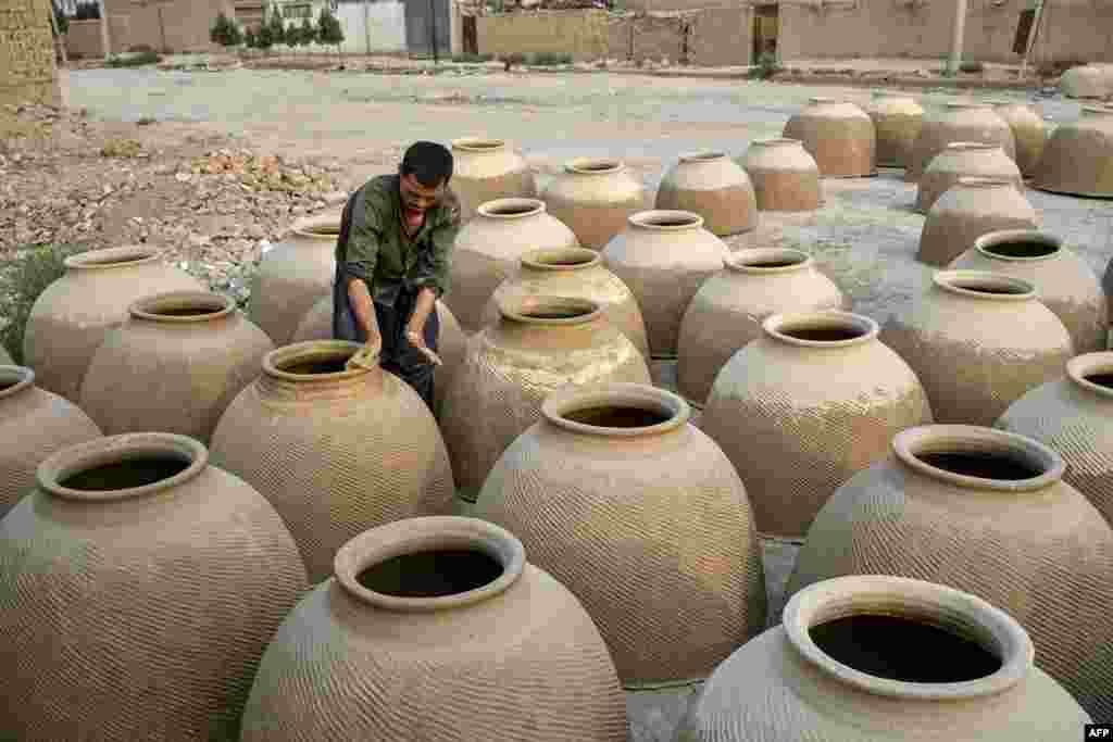 An Afghan man prepares tandoor clay ovens, traditionally used for baking naan or bread, in Mazar-e Sharif.