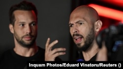 Tristan and Andrew Tate (right) talk to reporters in front of their house in Romania after their return to the country on March 22.