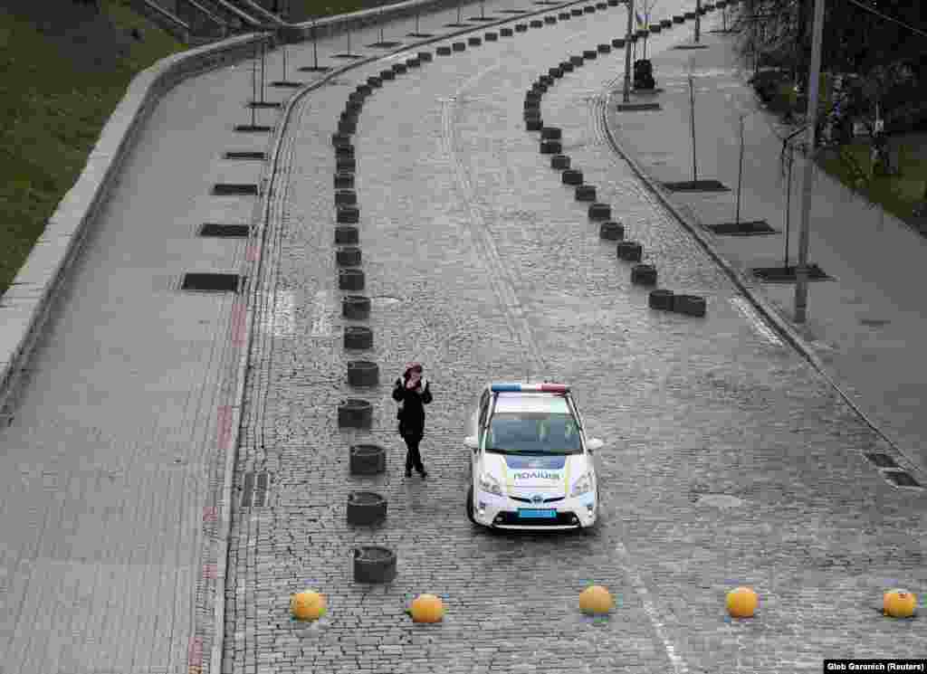 A police officer smokes on an empty street while patrolling central Kyiv on March 31. (Reuters/Gleb Garanich)