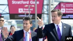 British Prime Minister David Cameron (right) speaks to London Olympics organizer Sebastian Coe during a visit to the Olympic Park in London on July 26.