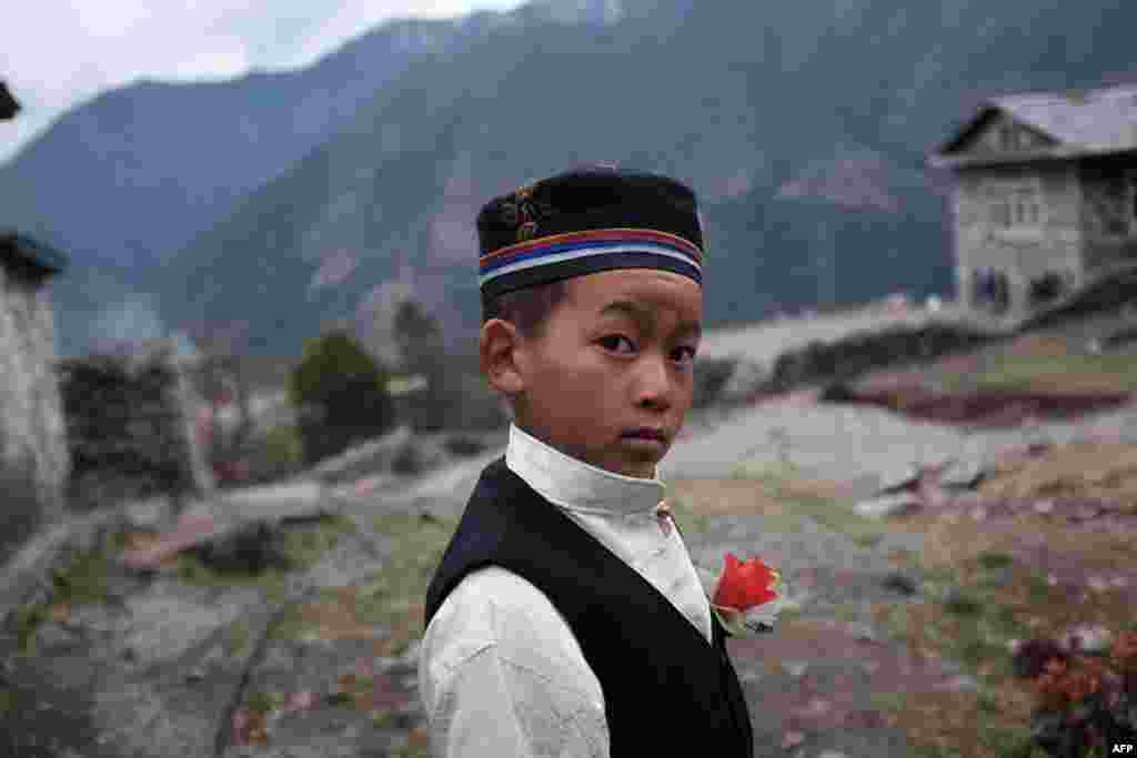 Rinji, 10, a young resident of the northeastern Nepalese town of Lukla, wears a plastic flower on his lapel near his school. (AFP/Roberto Schmidt)