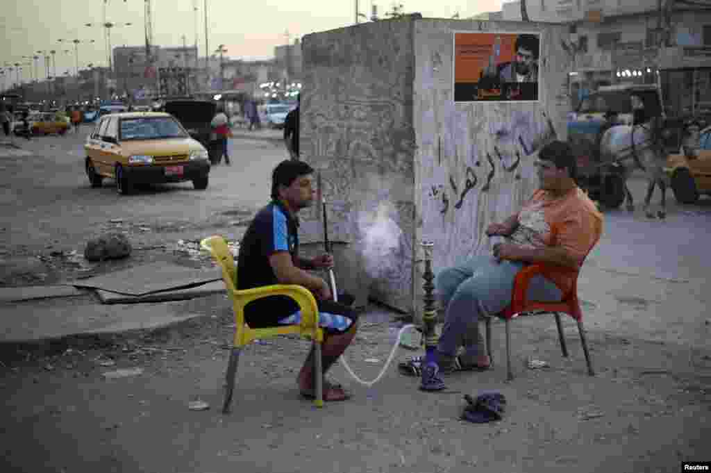 Young men smoke water pipes in Sadr City.