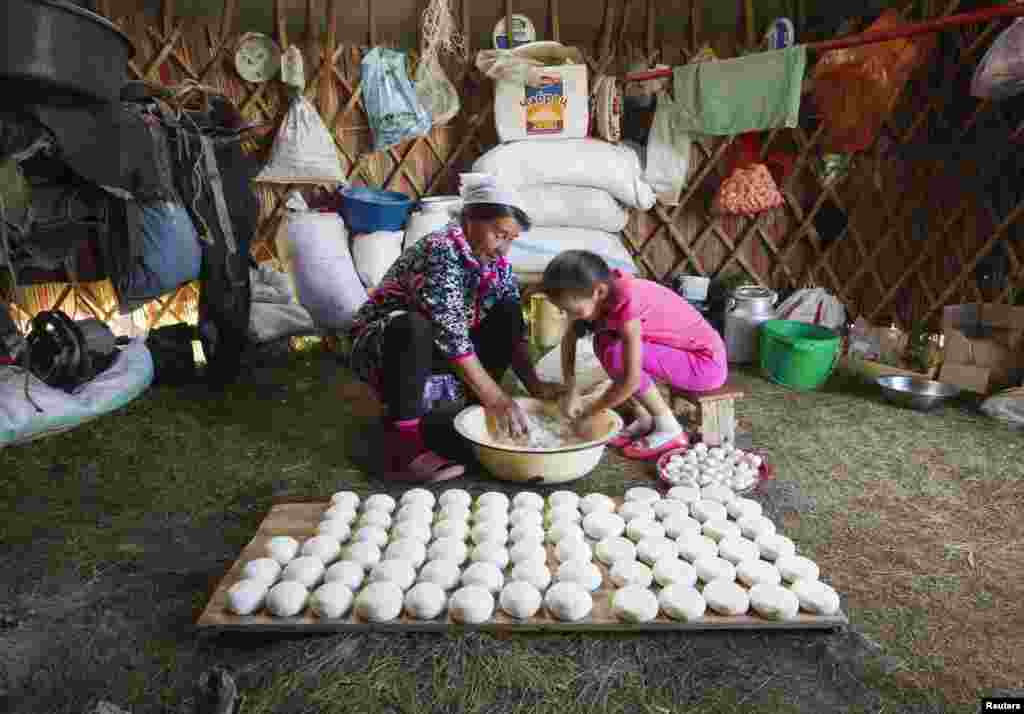 Zhambytai Zhumaliyava and her granddaughter Ayazhan prepare traditional cheese curd balls, which are left out to dry.