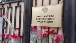 Кыргызстанцы несут цветы к Посольству России