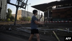 A man walks past a damaged supermarket following a Russian missile strike in the Ukrainian capital of Kyiv on August 1.
