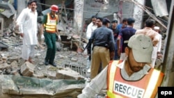 Rescue worker inspects the scene of the attack at the Sufi shrine