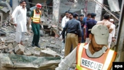 Rescue worker inspects the scene of the attack at the Sufi shrine 