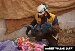 Доброволец "Белых касок" с телом девочки, погибшей во время бомбардировки Алеппо в 2020 году