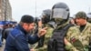 Участник протеста разговаривает с полицейским в Магасе, Ингушетия