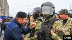 Участник протеста разговаривает с полицейским в Магасе, Ингушетия