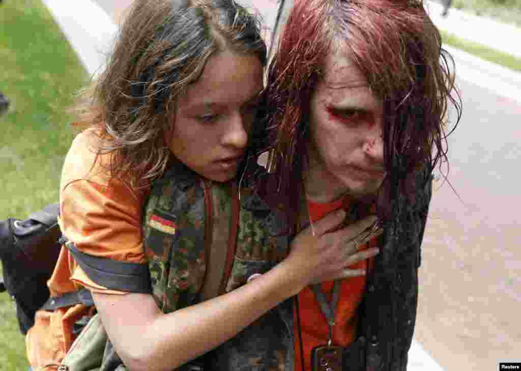 A gay-rights activist is comforted by a supporter after being attacked during the protest outside the State Duma.