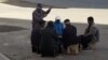 Turkmenistan. Men sitting on the stool outside and having a talk. Ashgabat. December 2018.