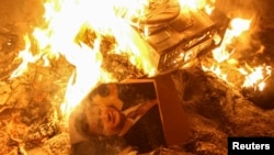 Un portret al lui Ianukovici arrzând lângă sediul serviciilor secrete din Liov, 19 februarie 2014