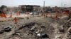 People inspect a destroyed oil pump station a day after a truck bomb blast that targeted Green Village compound in Kabul on September 3.