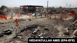 People inspect a destroyed oil pump station a day after a truck bomb blast that targeted Green Village compound in Kabul on September 3.