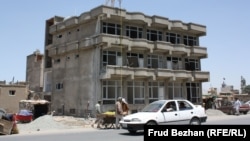 An apartment building stands unfinished on a street in Kabul