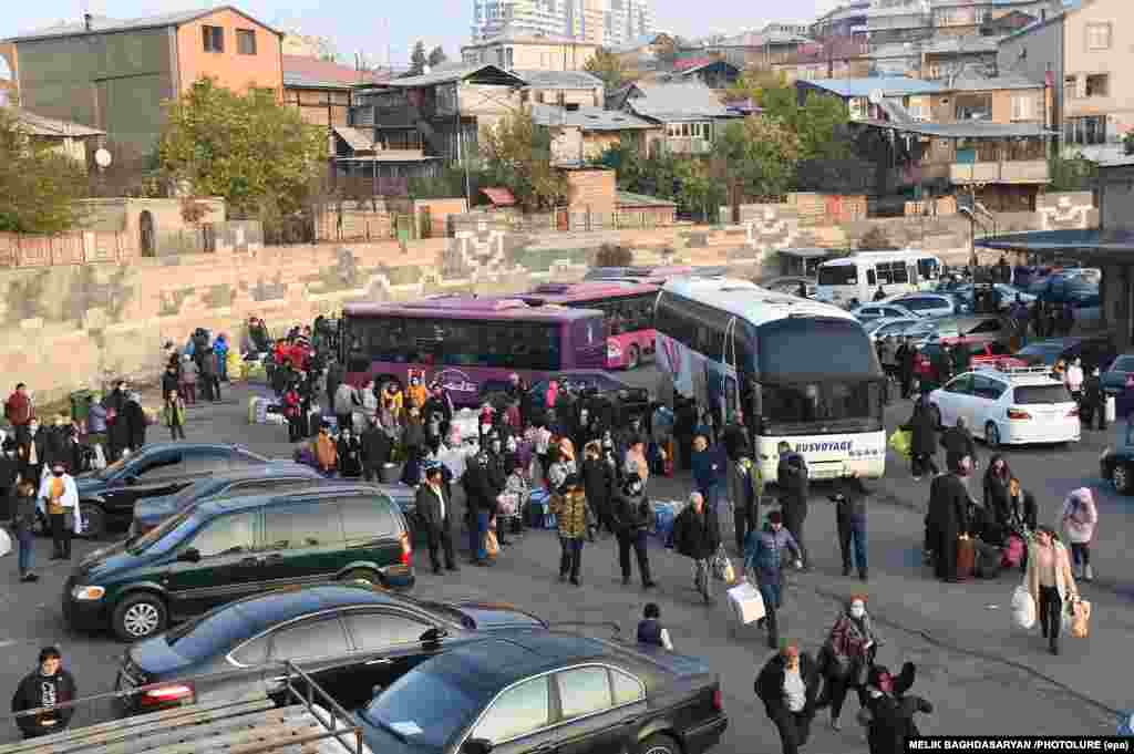 Refugees who fled Stepanakert as fighting raged around the city through October board busses in Yerevan to return to their homes on November 18.