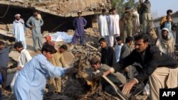 Pakistani volunteers and local residents search for blast victims in the rubble following the suicide car-bomb blast on the outskirts of Peshawar on November 16.