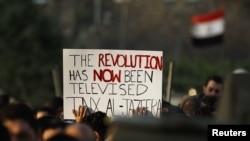 Egyptian antigovernment protesters carry a sign outside the Egyptian television center in Cairo during demonstrations that toppled the Mubarak regime in February 2011.