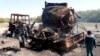 Police officers inspect the site of the September 2009 air strike in Kunduz, which had been ordered by a German commander who feared the Taliban could use the fuel tankers to carry out attacks.