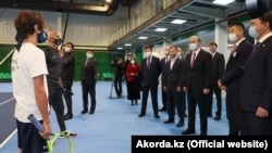 Президент Казахстана Касым-Жомарт Токаев (в центре) во время посещения теннисного центра в Караганде. По его правую руку — бизнесмен Булат Утемуратов. 23 ноября 2020 года.