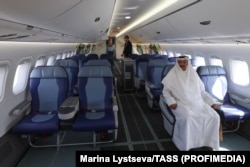 A man tests one of the seats inside an MC-21 during its display at the Dubai Airshow in November 2021.