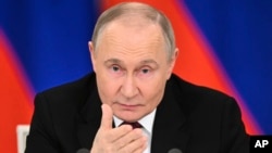 Russian President Vladimir Putin gestures as he speaks to journalists at the Kremlin early on May 11.