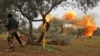 Members of Syria's opposition "National Liberation Front" fire heavy artillery guns at government forces near the town Taftanaz in northeastern Idlib province, from another position, February 28, 2020