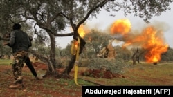 Members of Syria's opposition "National Liberation Front" fire heavy artillery guns at government forces near the town Taftanaz in northeastern Idlib province, from another position, February 28, 2020