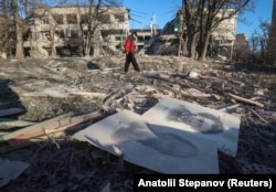 Житель Слов'янська Донецької області проходить повз будівлю школи, зруйнованої внаслідок російських авіаударів під час нападу Росії на Україну. Україна, 25 листопада 2025 року/