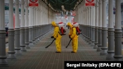 Russian Emergency Situations Ministry workers sanitize a railway station in Moscow on June 11 amid a steep increase in infections.