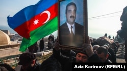 Mourners carry an Azerbaijani flag and a portrait of Zaur Ahmadov, who died four days after he lit himself on fire in Baku to protest perceived mistreatment.