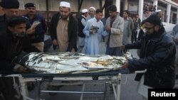 Pakistani rescue workers wheel the body of Farzana, a female polio campaigner, at Peshawar Hospital on December 18.