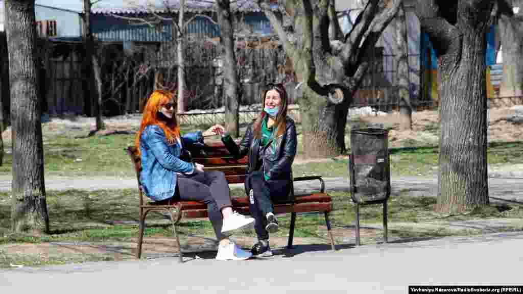 Двоє дівчат сидять на лавці на центральній алеї парку Гагаріна у Запоріжжі, 6 квітня 2020 року