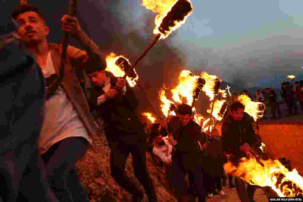 People participate in a torch procession during celebrations of the Norouz new year in Iraq&#39;s Kurdish region on March 20. (epa-EFE/Gailan Haji)