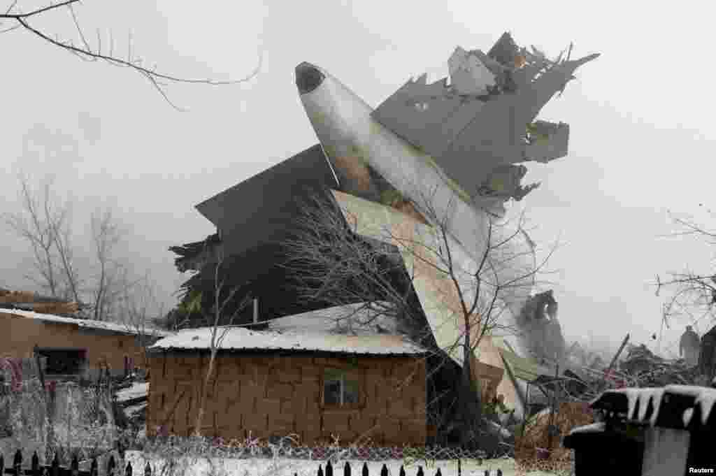 The tail section of the Boeing 747 lying among damaged houses in Dacha-Suu, outside of the capital, Bishkek.