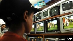 A young boy watches an Indian soap opera in a Kabul electronics shop.