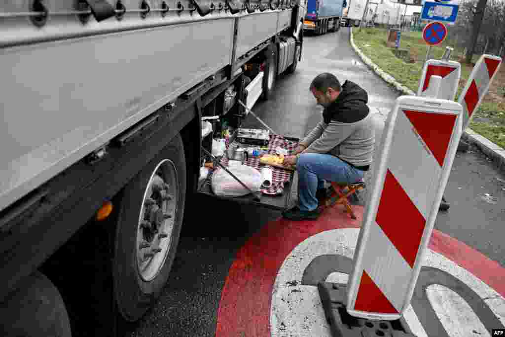 Turski vozač kamiona priprema obrok na graničnom prelazu Batrovci između Srbije i Hrvatske, dok stotine vozača kamiona blokiraju teretne granične prelaze, 26. januar 2026. godine