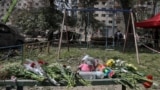 Цветы и игрушки рядом с домом в Киеве, в котором обрушился подъезд в результате российского удара 17 июня