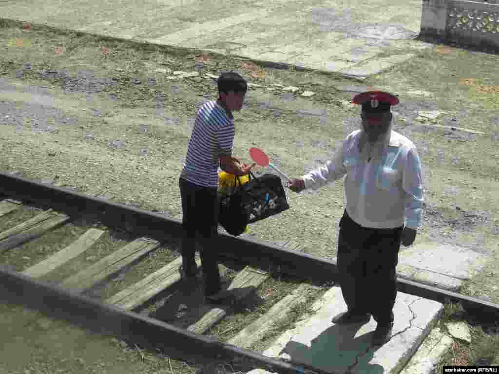 Demir ýoluň ugrunda duran oglan we demir ýol ulgamynyň işgäri