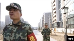 Security guards outside the Olympic Village in Beijing