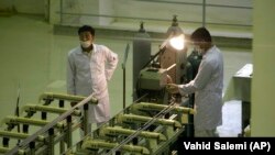 FILE - In this April 9, 2009 file picture Iranian technicians work at a new facility producing uranium fuel for a planned heavy-water nuclear reactor, just outside the city of Isfahan, 255 miles (410 kilometers) south of the capital Tehran. Iran is laggi