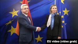 The EU’s foreign policy chief, Federica Mogherini, greets Armenian President Serzh Sarkisian (EU leaders prepare to meet Eastern Neighbors - video grab) 